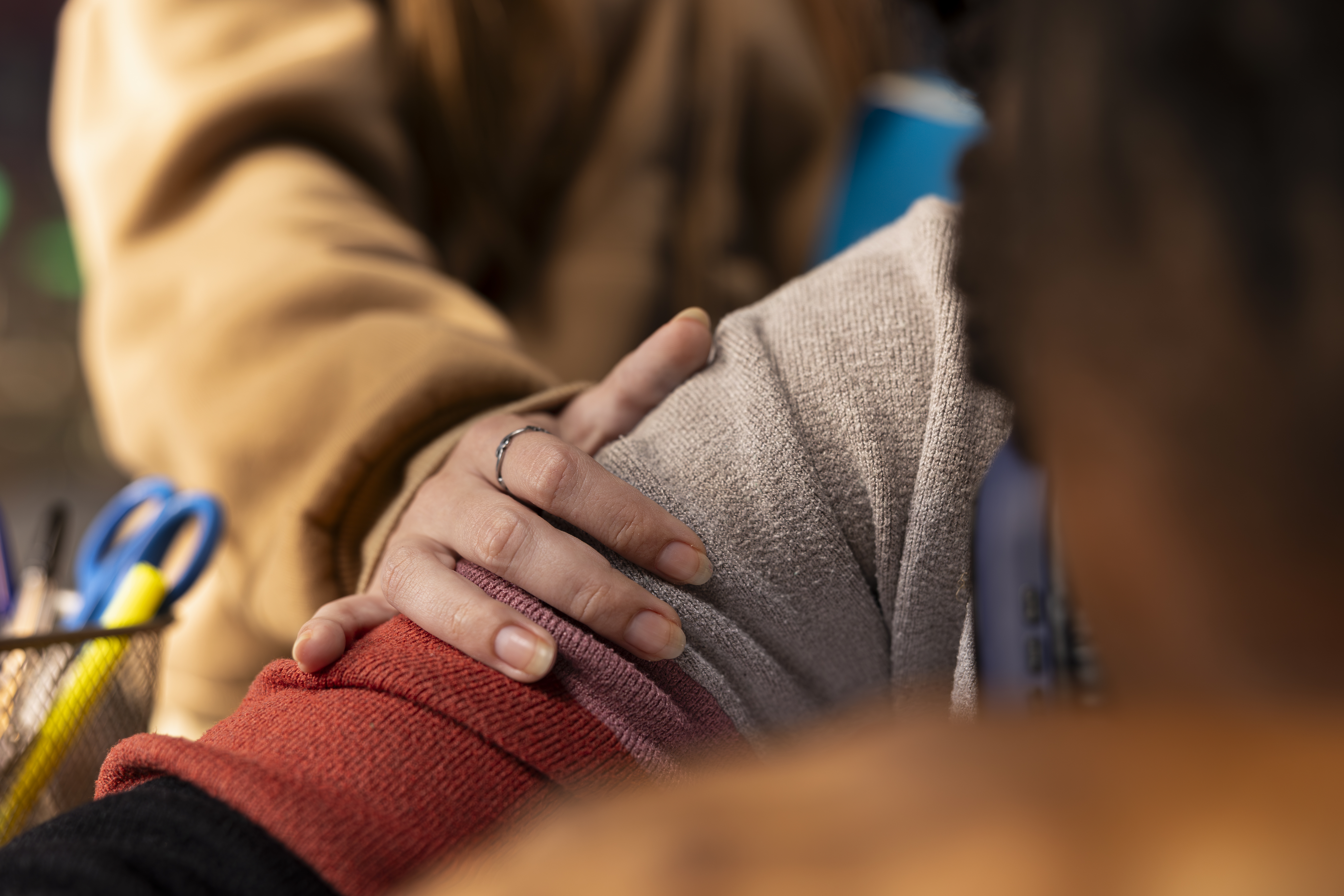 A woman's hand resting on a person's shoulder
